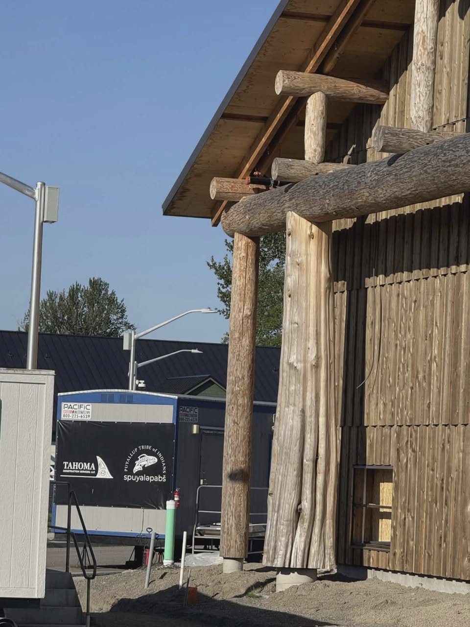 Longhouse detail showing Tahoma Construction Services trailer with spuyaləpabš logo